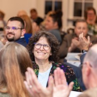 Suzanne Zack smiling as people clap for her